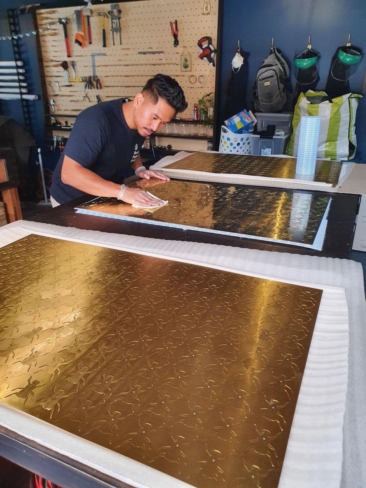 Fabricator Gian Salamanque polishing the brass sheet